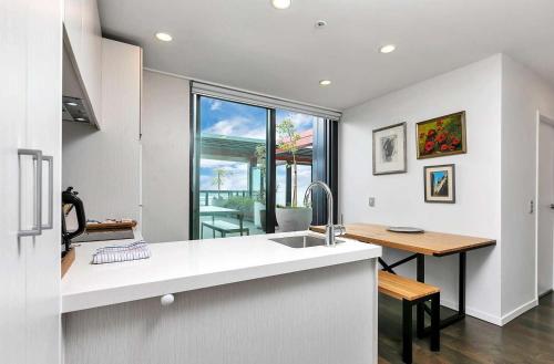 a kitchen with a sink and a counter with a table at City and view holiday home in Auckland