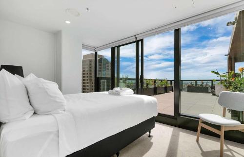 a bedroom with a white bed and a large window at City and view holiday home in Auckland