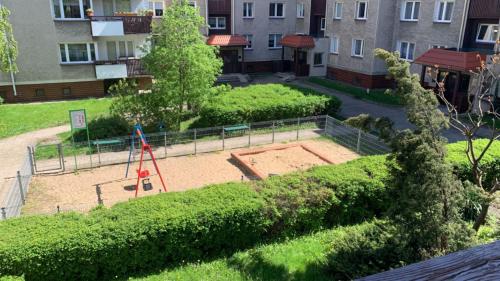 een tuin met een speeltuin in het midden van een gebouw bij Golden Apartament Legionów in Toruń