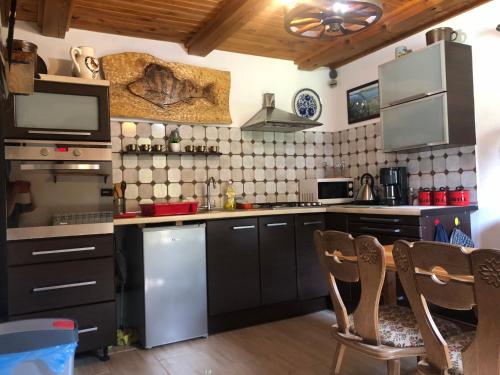 kuchnia z czarnymi szafkami oraz stołem i krzesłami w obiekcie Wigierska Chatka w Gawrych Rudzie