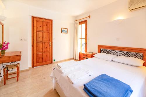 a bedroom with a large white bed and a desk at Korsan Apartment No.5 in Kaş