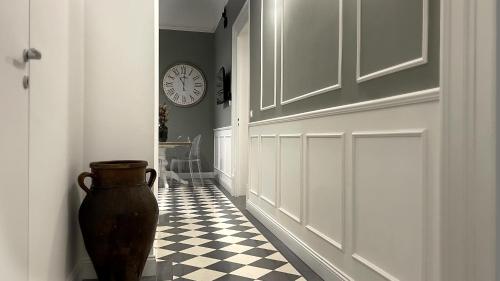 a hallway with a vase and a clock on the wall at Dimora Borghese “Whitaker” in Palermo