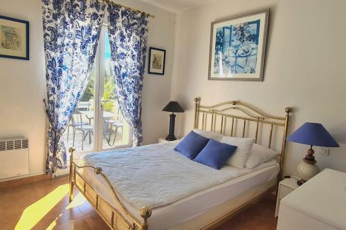 a bedroom with a bed with blue and white curtains at Maison Partina avec Piscine in Santa-Maria-di-Lota