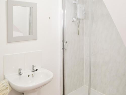 a white bathroom with a sink and a shower at Swans Nest - Uk43545 in Belford