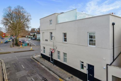 a white building on the side of a street at The Cotswold Woodland by Fortuna Property Portfolio in Cheltenham