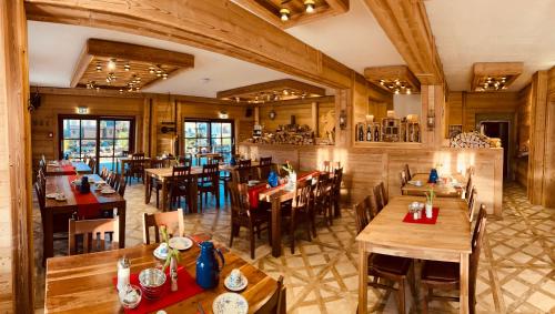 um restaurante com pisos e mesas e cadeiras de madeira em Hotel Seidl em Straßlach-Dingharting