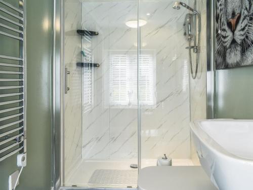 a shower with a glass door in a bathroom at The Old Post House in Walton