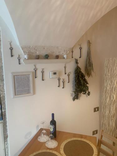 una sala da pranzo con tavolo e bicchieri da vino sul muro di Impressioni in Valle D’Itria a Martina Franca