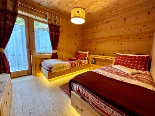 - une chambre avec 2 lits dans une cabane en rondins dans l'établissement Al Bait Del Legn, à Bormio