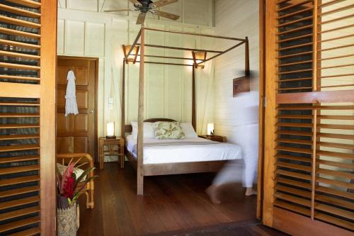 a bedroom with a canopy bed in a room at Bluff Beach Retreat in Bocas Town