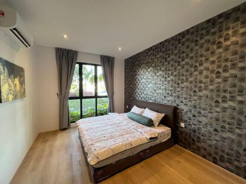 een slaapkamer met een groot bed en een stenen muur bij Armadale Residence Galacity 3 bedroom in Kampong Tabuan