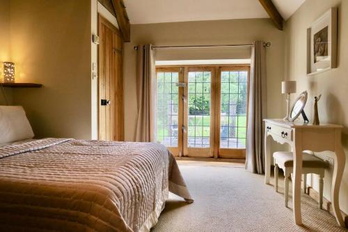 a bedroom with a bed and a sliding glass door at The Tallet - converted three bed stable - no children under 8 in Yeovil