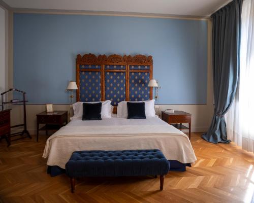 a large bedroom with a large bed with a blue headboard at Albergo Pietrasanta in Pietrasanta