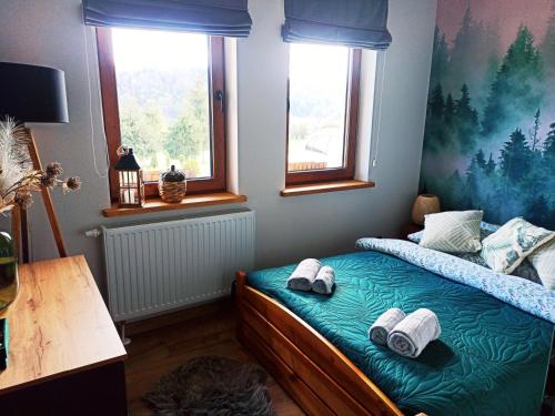 1 dormitorio con 1 cama con toallas en Willa Maja Bieszczady noclegi Bieszczady, en Mchawa