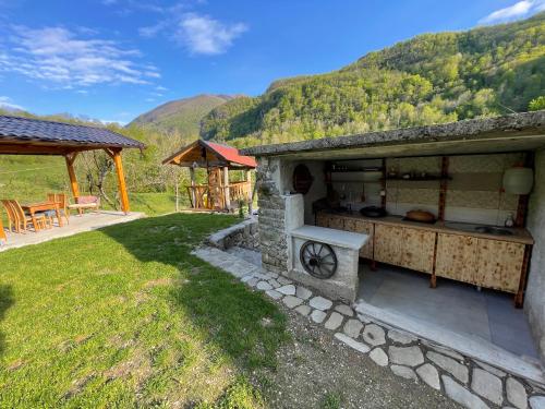 a outdoor kitchen with a table and a grill at Hurja Apartments in Kobarid