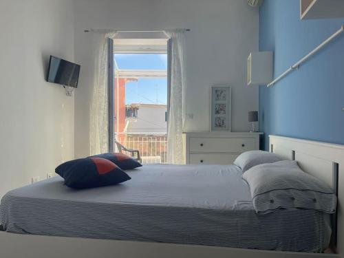 sypialnia z łóżkiem z poduszkami i oknem w obiekcie Pennino studios Bacoli w mieście Bacoli