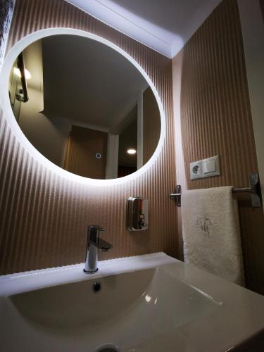a bathroom with a sink and a large mirror at Apartamento MS in Campo Maior