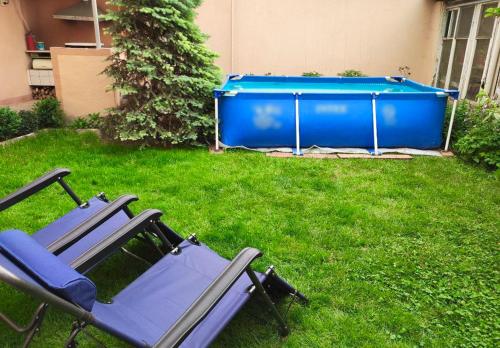 a couple of lawn chairs in a yard with a pool at FRОDО - Cozy as a home for 4-6 persons in Tashkent
