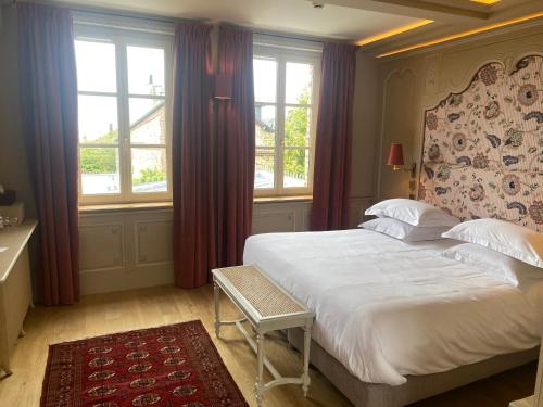 een slaapkamer met een groot wit bed en ramen bij La Petite Lucie in Honfleur