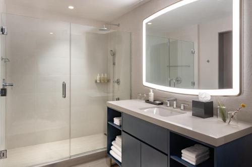a bathroom with a sink and a shower with a mirror at JW Marriott Clearwater Beach Resort & Spa in Clearwater Beach