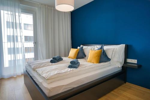 1 dormitorio azul con 1 cama grande y paredes azules en Modern apartment near Stadtpark en Viena