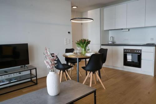 eine Küche und ein Esszimmer mit einem Tisch und Stühlen in der Unterkunft Modern apartment near Stadtpark in Wien