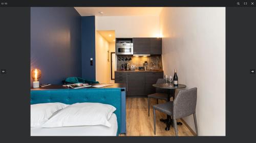 une chambre avec un lit bleu et une cuisine dans l'établissement Standing Bellecour Perrache, à Lyon