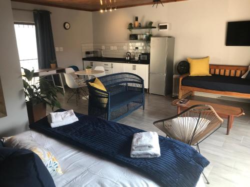a living room with a couch and a kitchen at Blue Lotus Guest House Pta East-Solar power in Pretoria