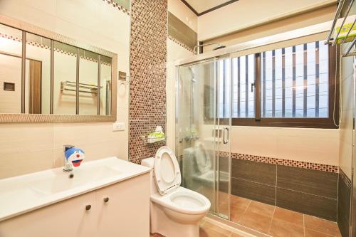 a bathroom with a toilet and a glass shower at Ching Yu Rou B&B in Dongshan