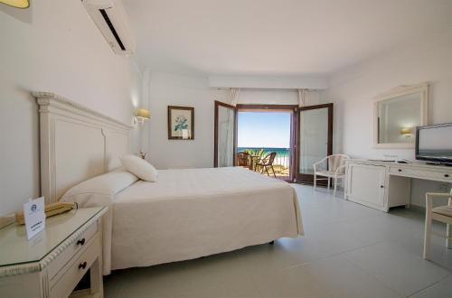 a bedroom with a bed and a desk and a television at Gran Sol in Zahara de los Atunes