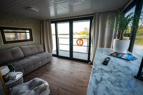 Domki na wodzie - Houseboats Zalesie with sauna : غرفة معيشة مع أريكة وطاولة مع نبات