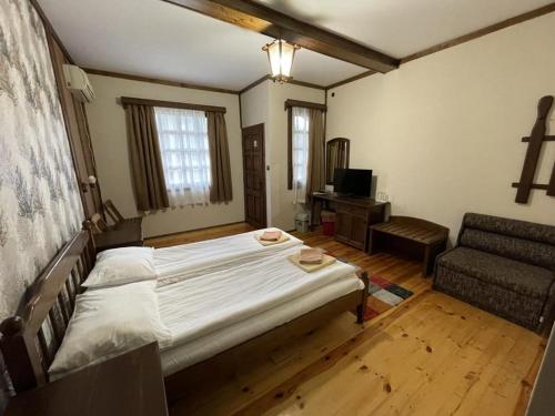 a bedroom with a large bed and a couch at Complex Barite in Chernevo