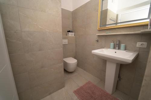 a bathroom with a sink and a toilet and a mirror at Beachfront Marilyn in Durrës