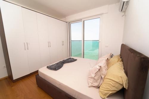 a bedroom with a bed and a large window at Beachfront Marilyn in Durrës