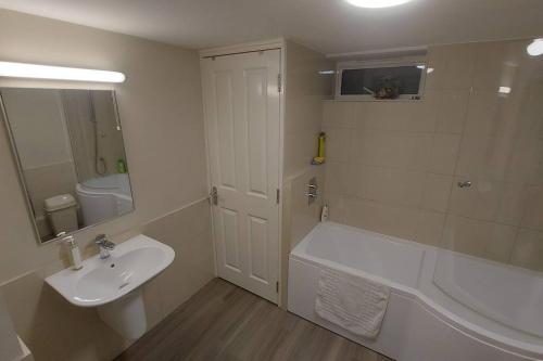 uma casa de banho com um lavatório, uma banheira e um WC. em The Den, 2 mins Chelt High Street, John Lewis etc em Cheltenham