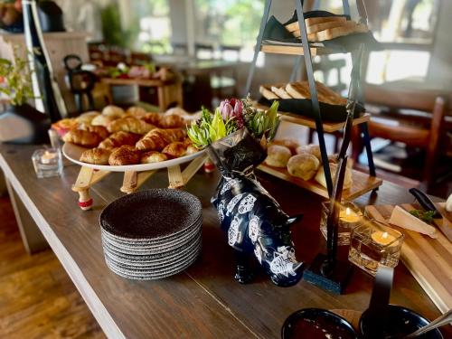 a table with a tray of pastries and plates of food at Karongwe - River Safari Lodge in Hoedspruit