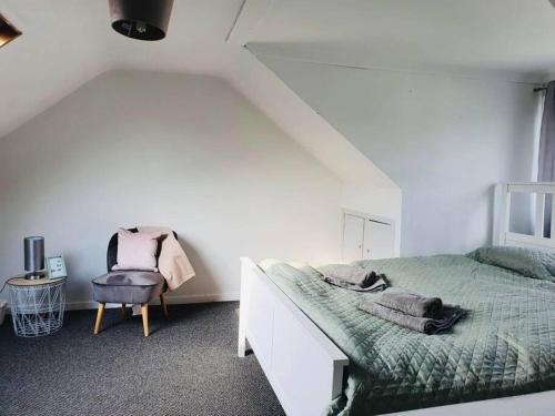 ein Schlafzimmer mit einem Bett und einem Stuhl in der Unterkunft Large home Swansea in Swansea