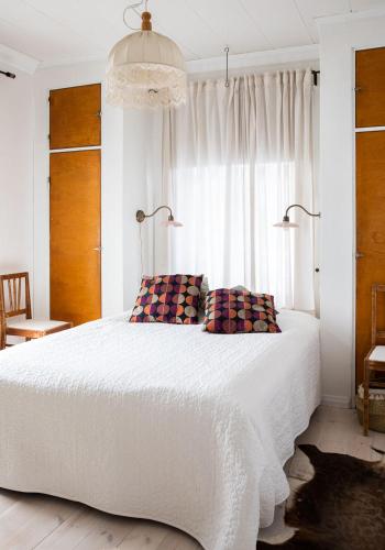 a bedroom with a large white bed with a window at Kerttula in Skinnarby