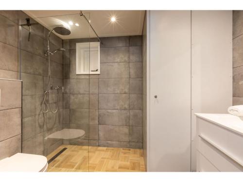 ein Bad mit einer Dusche und einem WC in der Unterkunft cozy holiday home in the centre of Zoutelande in Zoutelande