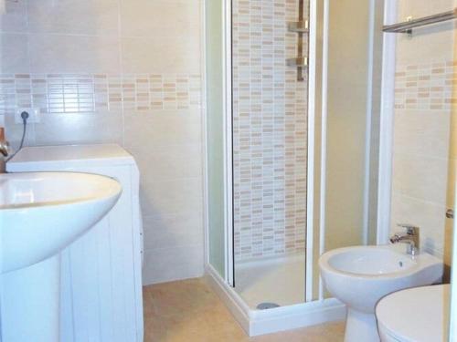 een badkamer met een wastafel, een toilet en een douche bij Spacious apartment in Porto Santa Margherita with shared pool in Porto Santa Margherita di Caorle