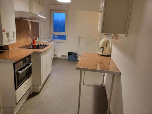 une cuisine avec des armoires blanches et un comptoir dans l'établissement domaine du nuton sauvage, à Charleville-Mézières