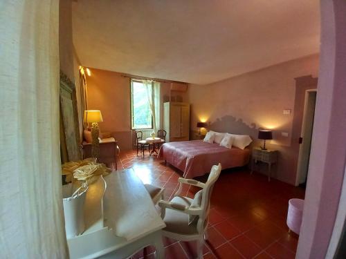 ein Hotelzimmer mit einem Bett, einem Tisch und Stühlen in der Unterkunft La Casa Rosa in Pigna