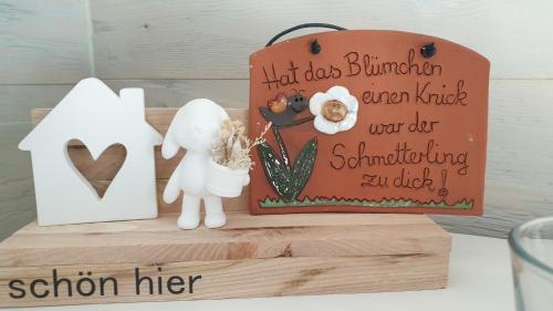 a cake with a couple and a sign on a table at Tinyhaus Wolkenlos Familie Hamdorf in Bad Sulza