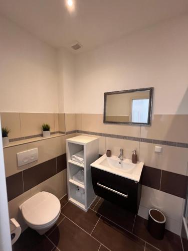 a bathroom with a sink and a toilet and a mirror at Apartment Södderich 1 in Waake