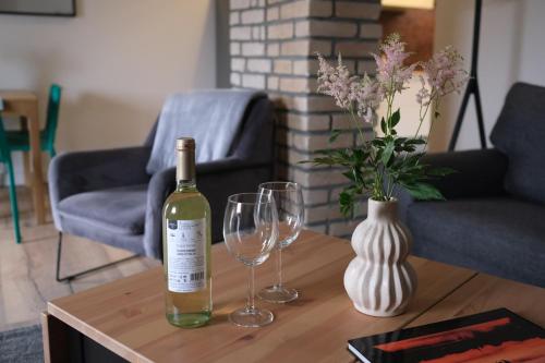 a bottle of wine and two glasses on a table at Apartament Tuchola in Tuchola