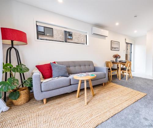 a living room with a couch and a table at Stylish home in Christchurch central in Christchurch