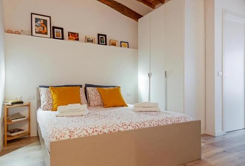 una camera da letto con un grande letto con cuscini gialli di CALIMARA18 25" from Florence AC SmartTV a Prato