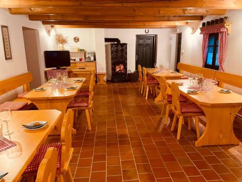a restaurant with wooden tables and chairs and a fireplace at Chalupy Betlém Hlinsko in Hlinsko