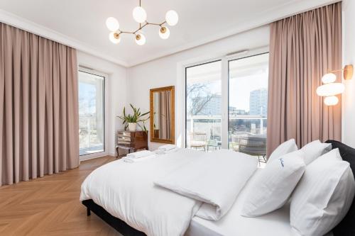 1 dormitorio blanco con 1 cama grande con almohadas blancas en Woronicza by Your Freedom, en Varsovia