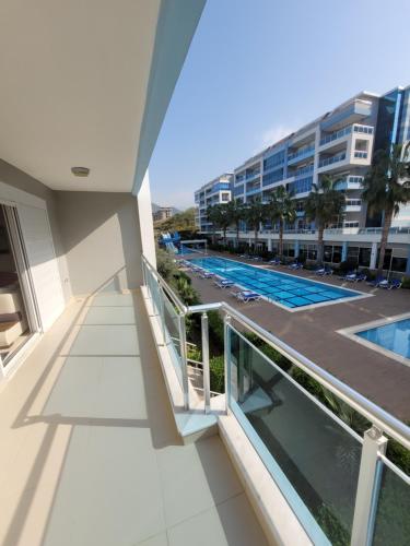 - un balcon avec vue sur la piscine et un bâtiment dans l'établissement Aura-B6-1BR-beautiful-Apt, à Alanya